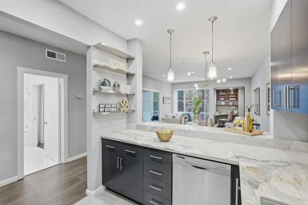 a kitchen with stainless steel appliances granite countertop a sink a counter space and cabinets