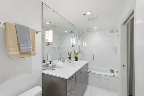 a bathroom with a bathtub shower sink vanity and a mirror