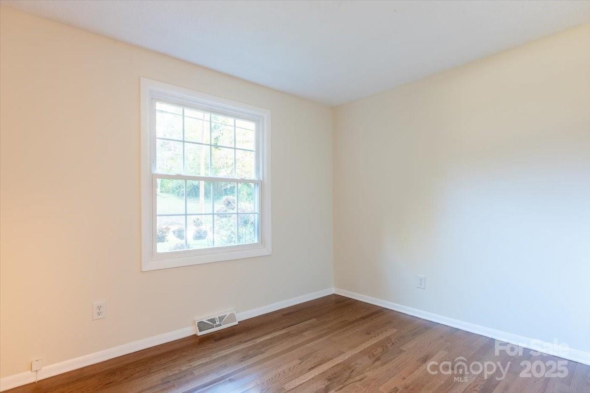 609 West Probart Street Brevard, NC 28712 - Photo 17 of 38 an empty room with wooden floor and windows