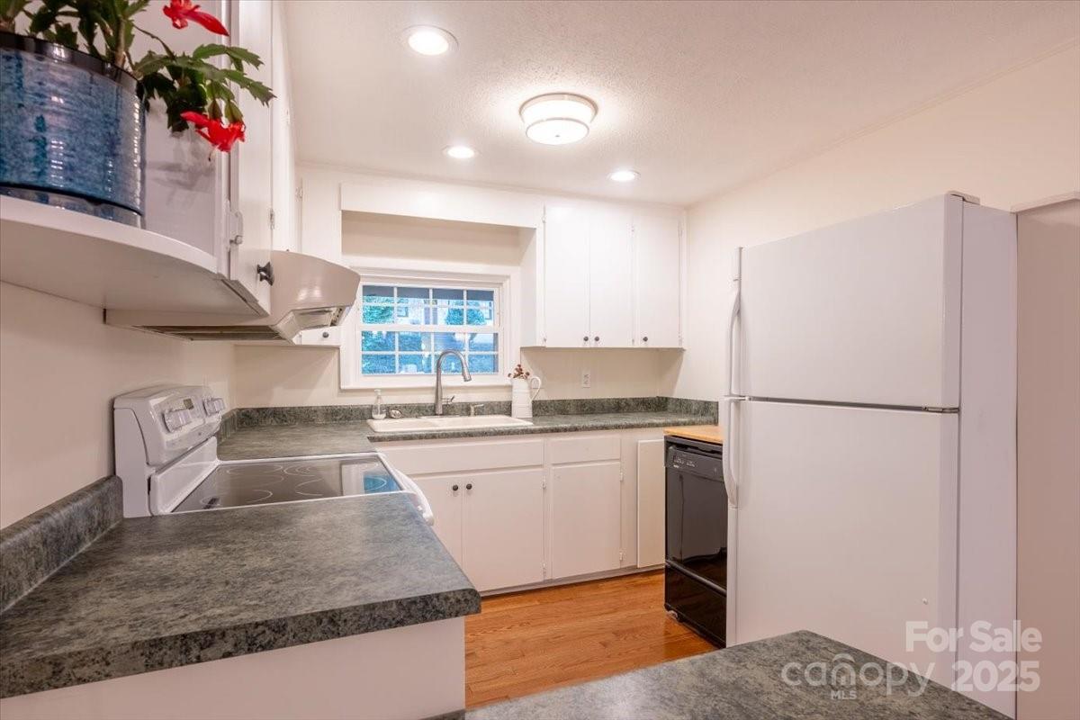 609 West Probart Street Brevard, NC 28712 - Photo 7 of 38 a kitchen with granite countertop a sink stainless steel appliances and cabinets