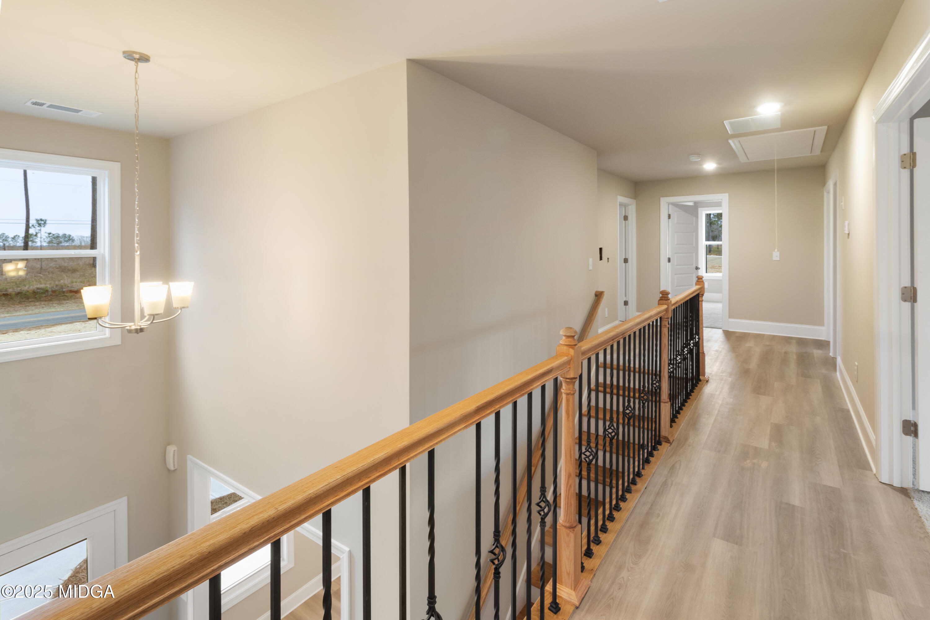 697 Giles Road Forsyth, GA 31029 - Photo 27 of 27 a view of a hallway with wooden floor and staircase