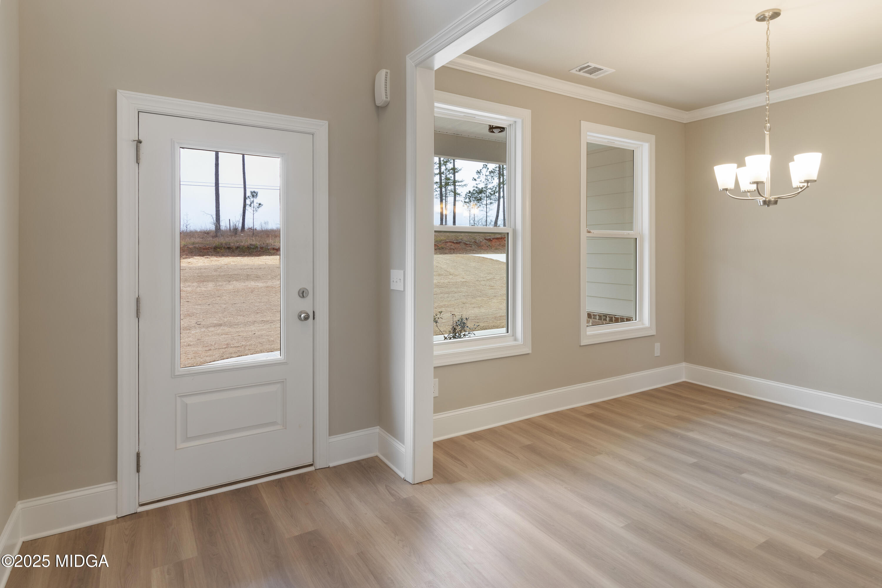697 Giles Road Forsyth, GA 31029 - Photo 6 of 27 an empty room with wooden floor and windows