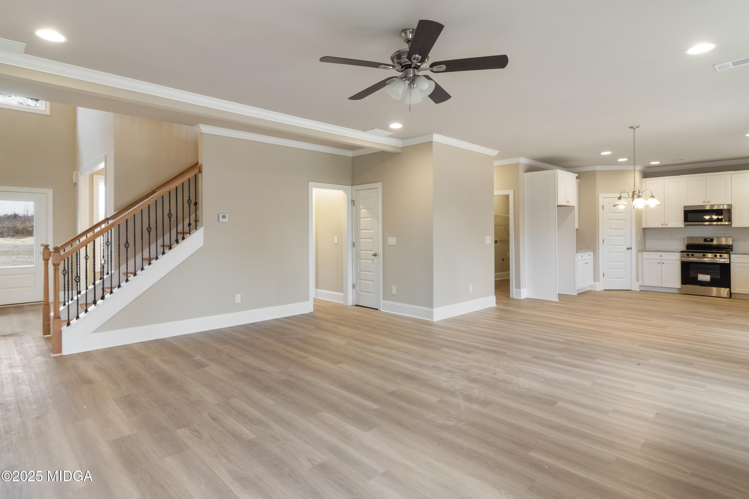 697 Giles Road Forsyth, GA 31029 - Photo 7 of 27 a view of an empty room with wooden floor and a ceiling fan