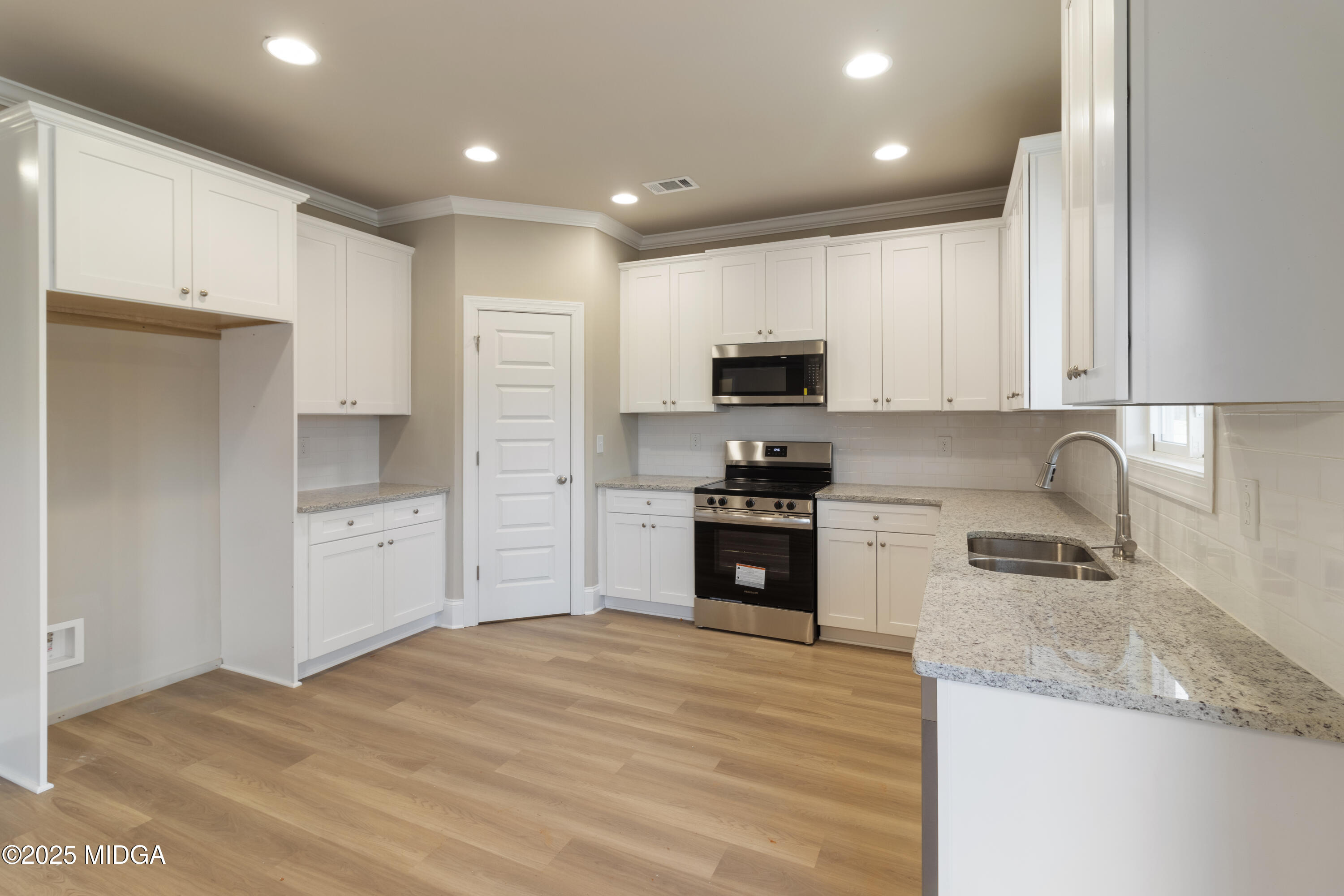 697 Giles Road Forsyth, GA 31029 - Photo 10 of 27 a kitchen with kitchen island granite countertop a stove sink and refrigerator