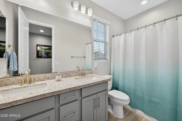 a bathroom with a granite countertop sink toilet and a mirror