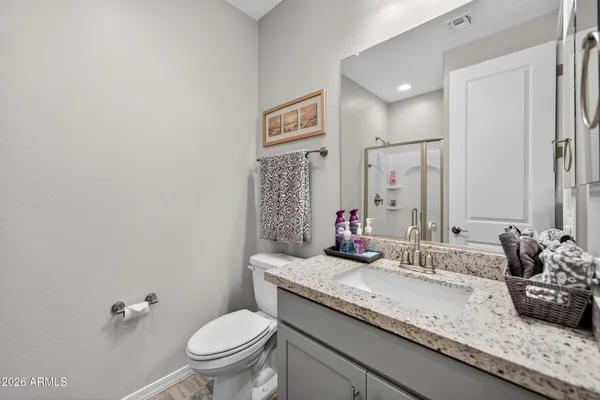 a bathroom with a granite countertop sink mirror vanity and toilet