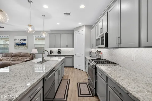 a kitchen with stainless steel appliances granite countertop a stove a sink and a microwave