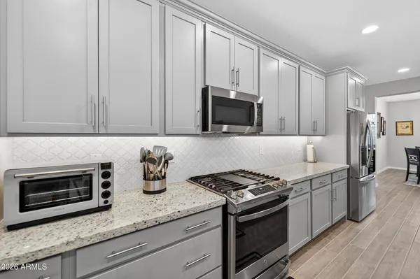 a kitchen with granite countertop stainless steel appliances a stove microwave and sink