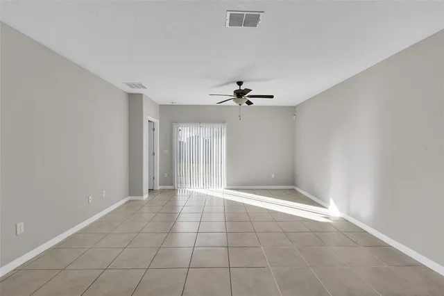 a living room with furniture a flat screen tv and a lamp