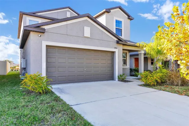 a front view of a house with a yard and garage
