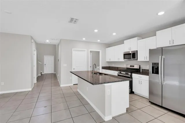 a kitchen with stainless steel appliances granite countertop a refrigerator and a stove