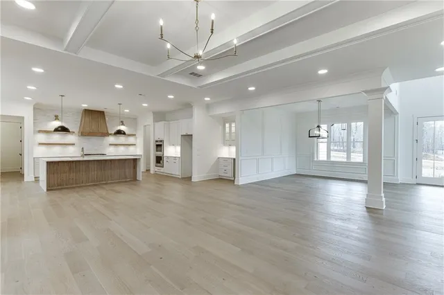 a view of a kitchen with a sink stainless steel appliances and a chandelier