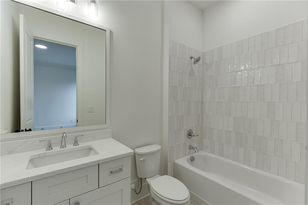 100 Gleneagles Way Pendergrass, GA 30567 - Photo 29 of 58 a bathroom with a bathtub shower sink vanity mirror and toilet