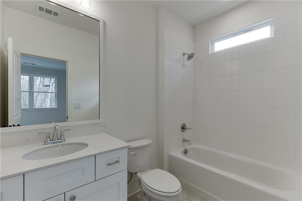 100 Gleneagles Way Pendergrass, GA 30567 - Photo 35 of 58 a bathroom with a granite countertop toilet a sink and a bathtub