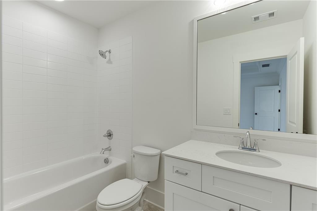 100 Gleneagles Way Pendergrass, GA 30567 - Photo 39 of 58 a bathroom with a granite countertop sink toilet and shower