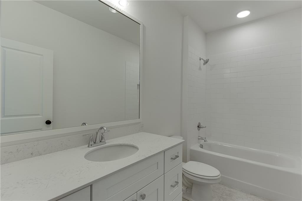 100 Gleneagles Way Pendergrass, GA 30567 - Photo 42 of 58 a bathroom with a granite countertop sink toilet and shower