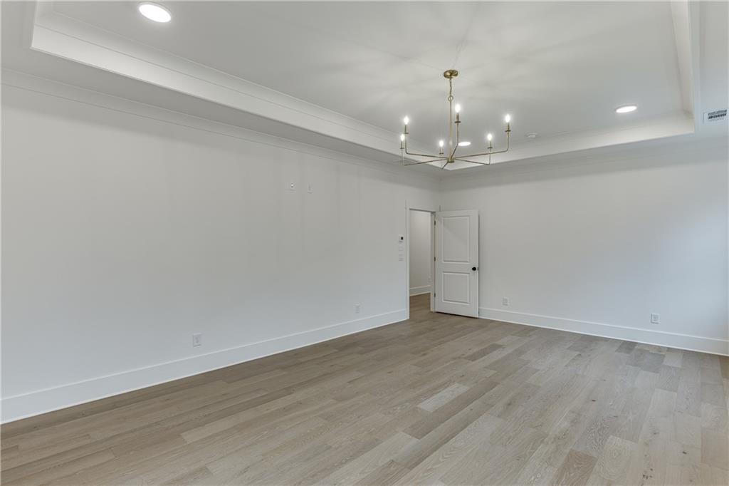 100 Gleneagles Way Pendergrass, GA 30567 - Photo 46 of 58 a view of an empty room with wooden floor and a chandelier
