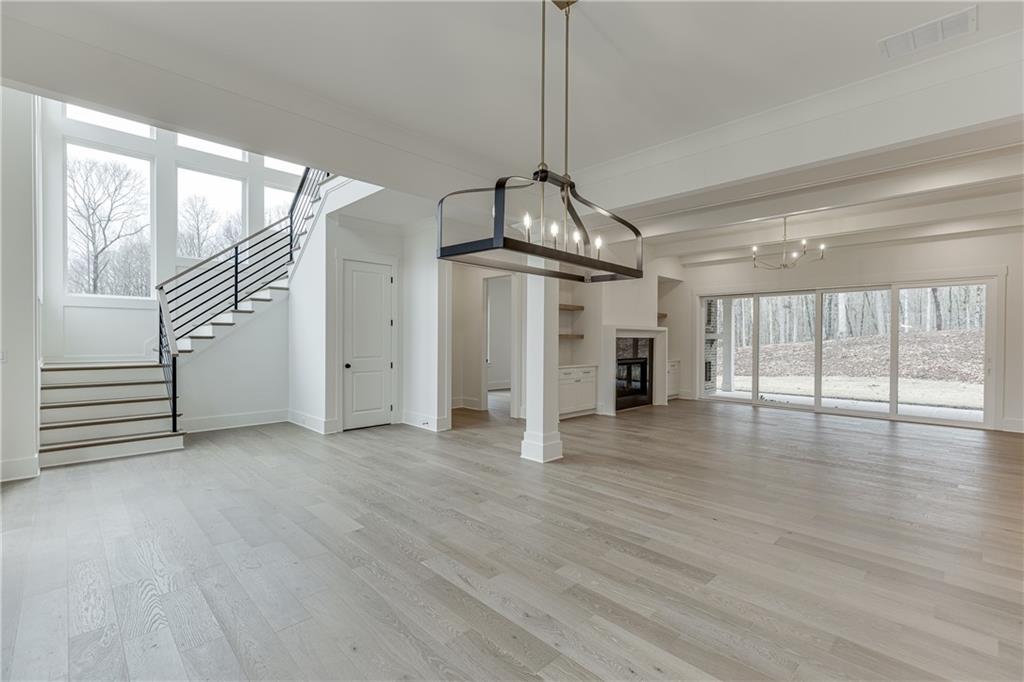 100 Gleneagles Way Pendergrass, GA 30567 - Photo 6 of 58 a view of a livingroom with wooden floor staircase and a kitchen space