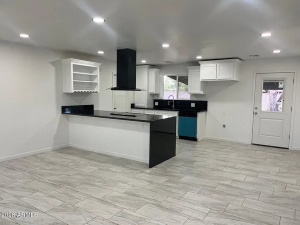 a large kitchen with stainless steel appliances granite countertop a sink and cabinets