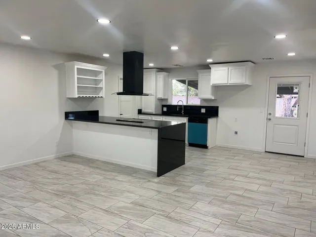 a large kitchen with stainless steel appliances granite countertop a sink and cabinets