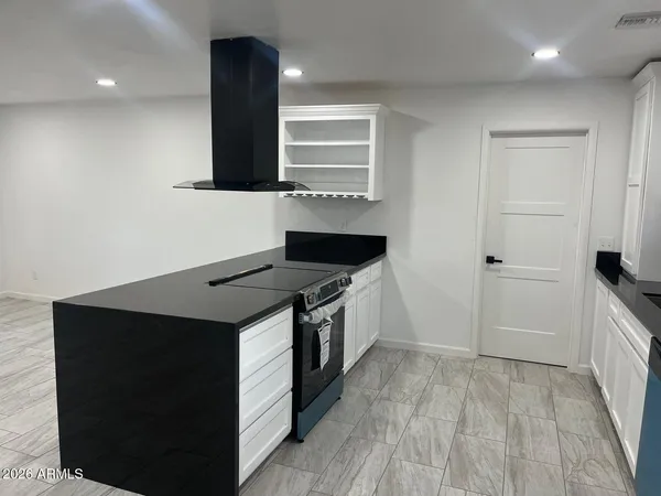 a kitchen with granite countertop a stove and a refrigerator