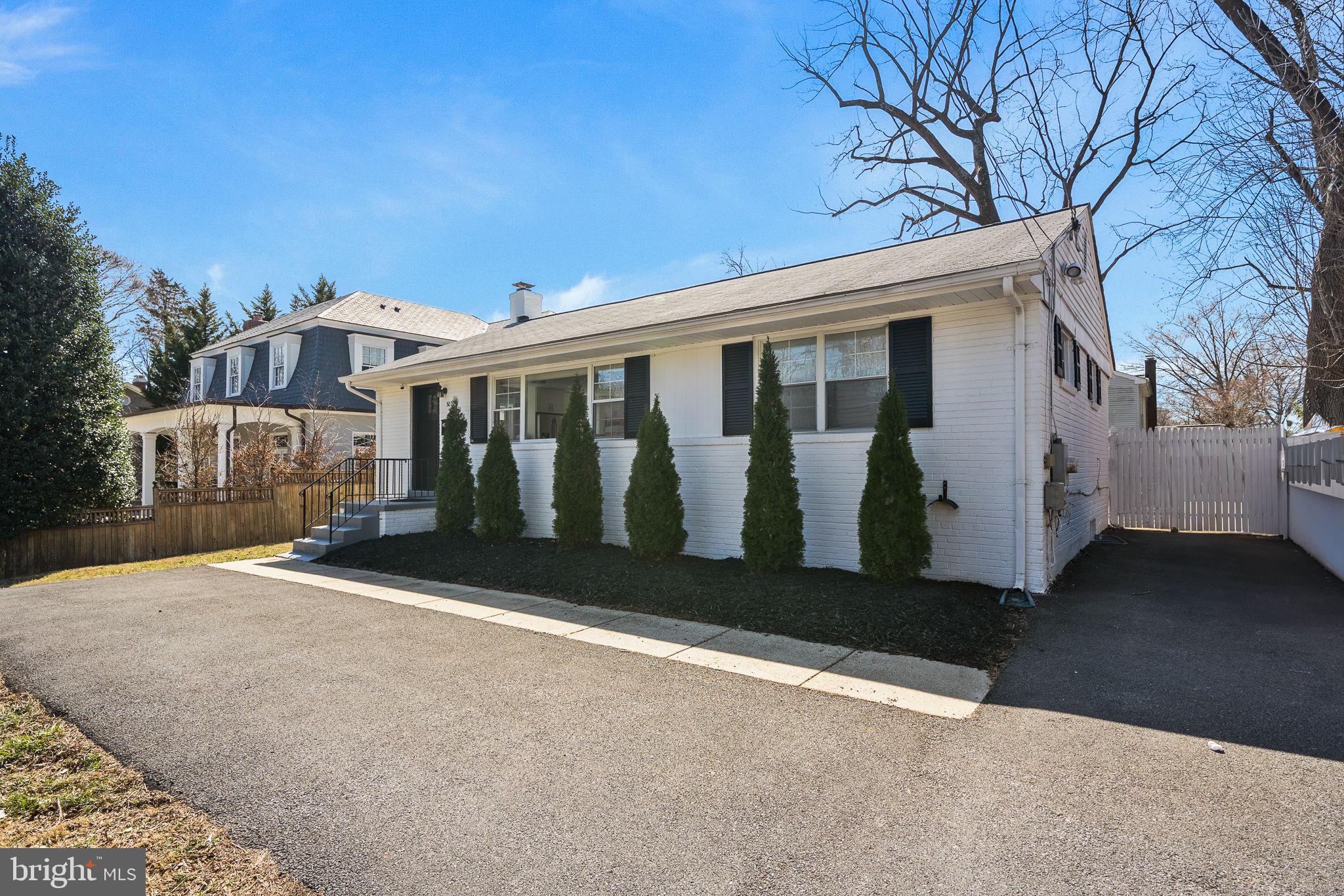 5020 River Road Bethesda, MD 20816 - Photo 2 of 36 a view of a white house with a big yard and large tree