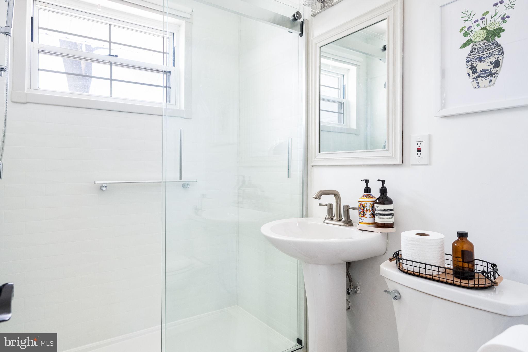 5020 River Road Bethesda, MD 20816 - Photo 22 of 36 a bathroom with a sink a mirror and a window
