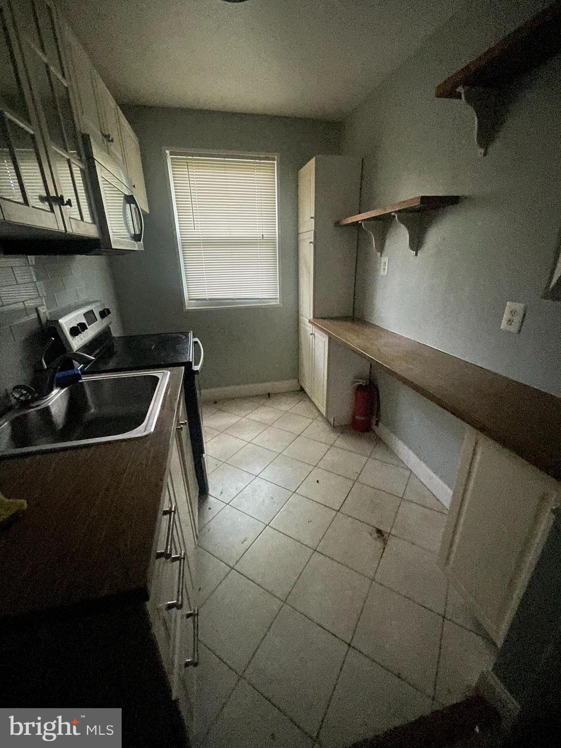 512 Ridge Road Southeast, Unit 105 Washington, DC 20019 - Photo 1 of 5 a kitchen with a sink a stove and a microwave
