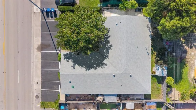 an aerial view of a house with a yard and large trees