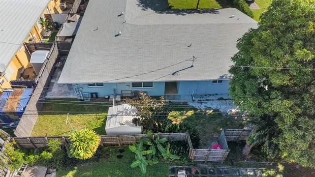 a view of a house with a yard potted plants and large tree