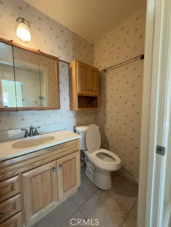 a bathroom with a granite countertop toilet a sink and a mirror