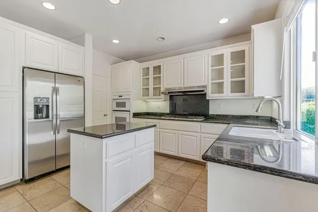 a kitchen with white cabinets and stainless steel appliances