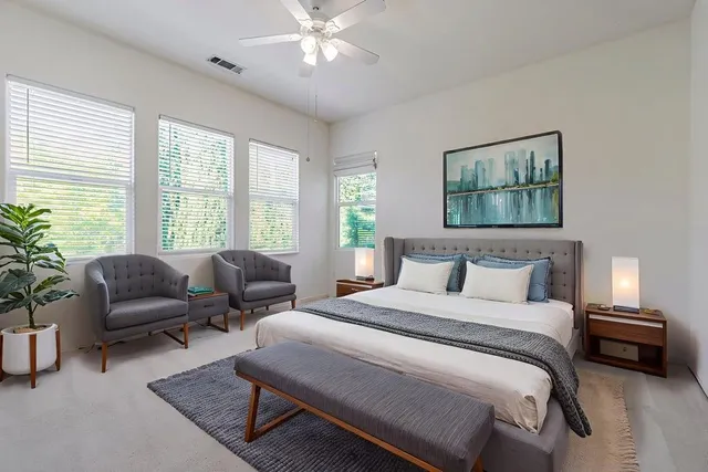 a spacious bathroom with a granite countertop sink a toilet and a large mirror