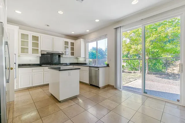 a dining room with wooden floor a chandelier a glass table and chairs