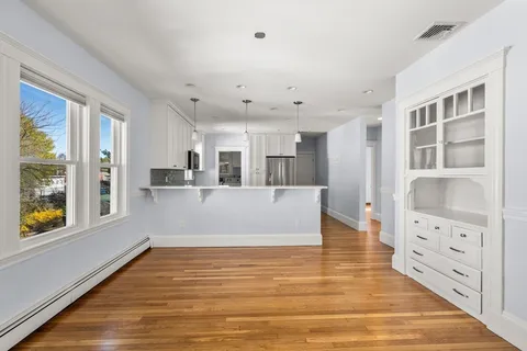 a view of a living room with furniture and large windows