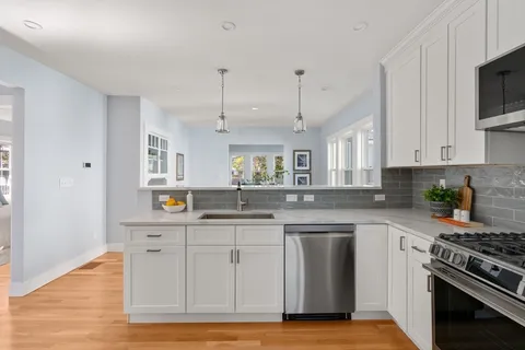 a kitchen with stainless steel appliances granite countertop a sink a stove a microwave and cabinets