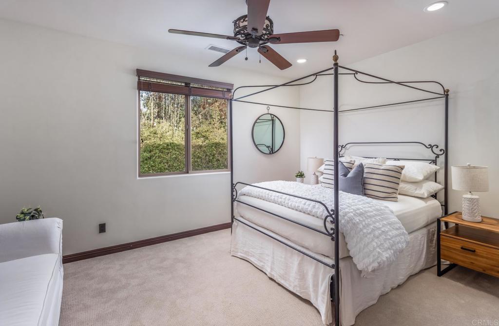 1133 Hermes Avenue Encinitas, CA 92024 - Photo 29 of 40 a bedroom with a bed a chandelier and a window