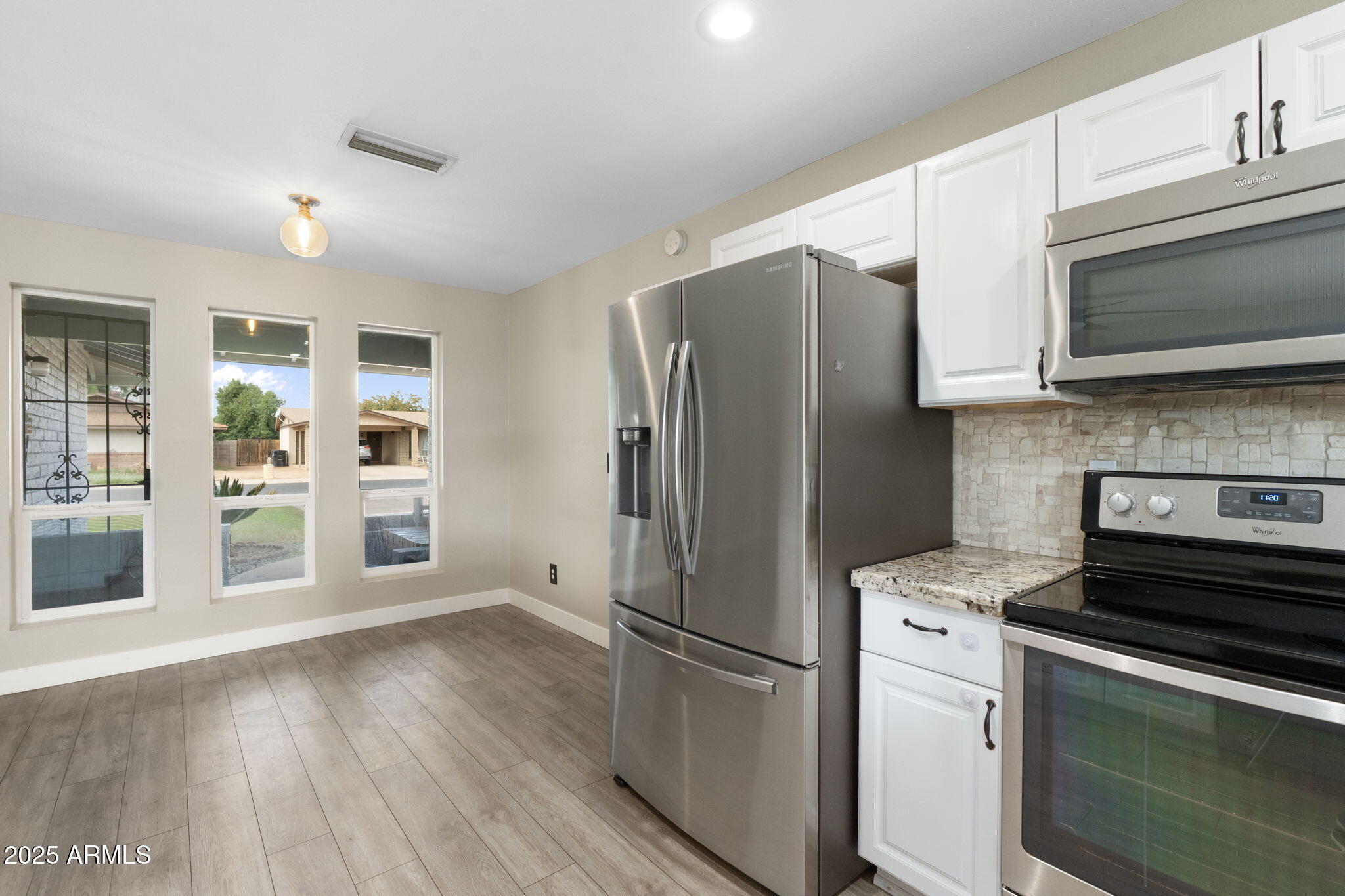 17 South Cholla Street Gilbert, AZ 85233 - Photo 12 of 37 a kitchen with stainless steel appliances a refrigerator microwave and stove