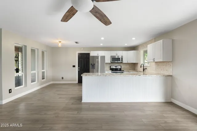 a large white kitchen with a white stove top oven and white cabinets