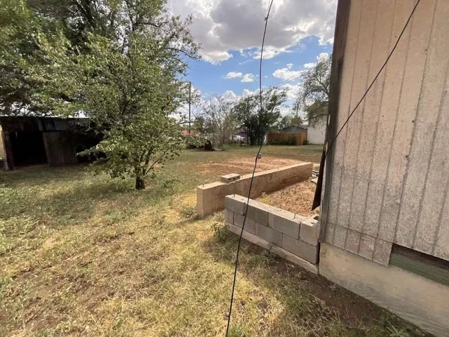 a view of a yard with wooden fence