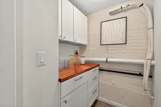 a kitchen with white cabinets and sink