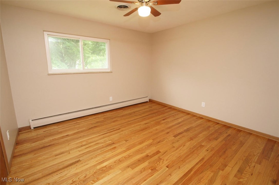7958 Bellflower Road Mentor, OH 44060 - Photo 25 of 34 Empty room with baseboard heating, light wood-style flooring, and a ceiling fan