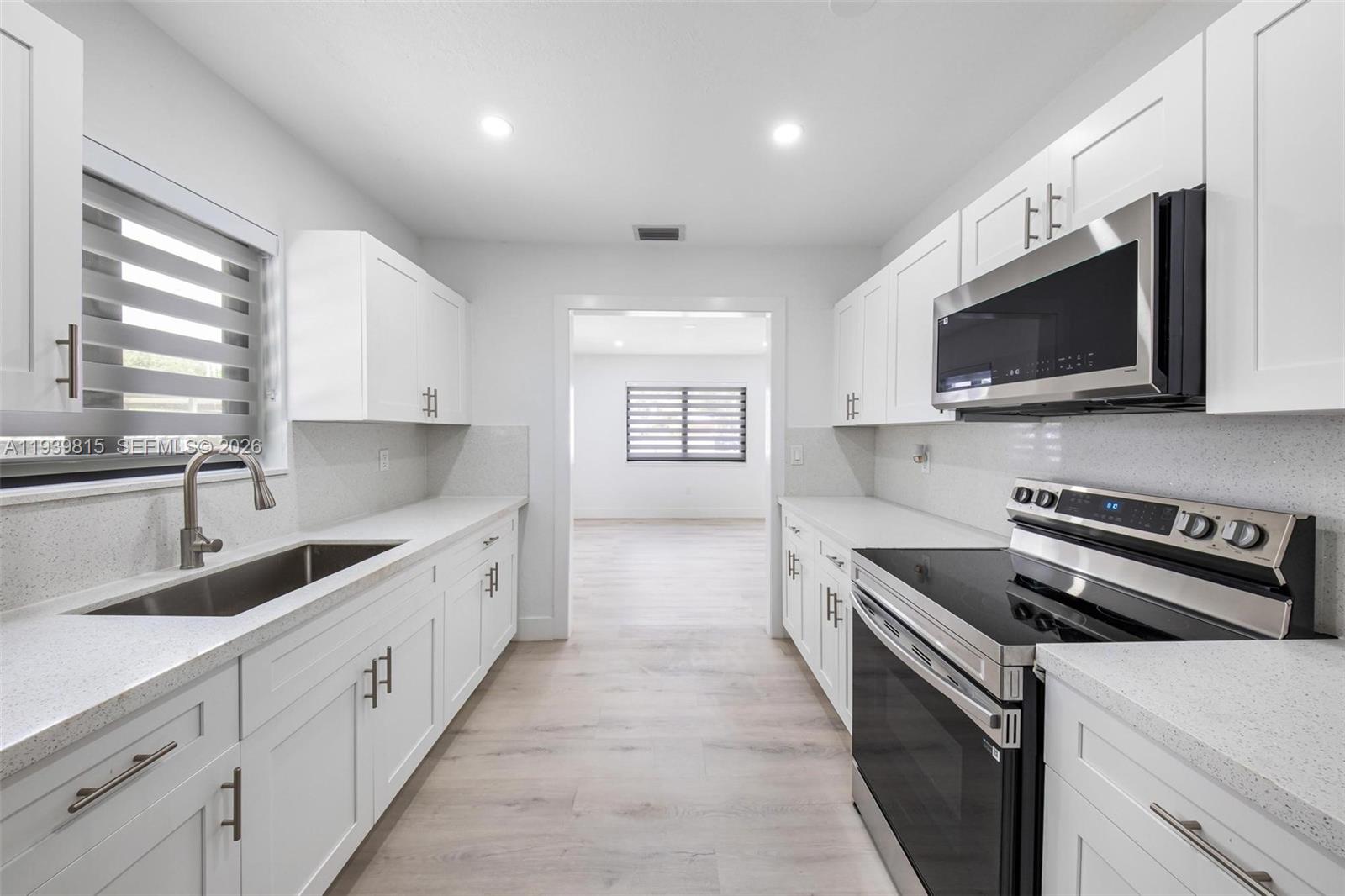 2250 Northwest 95th Street Miami, FL 33147 - Photo 11 of 26 a large kitchen with stainless steel appliances granite countertop a sink and a stove