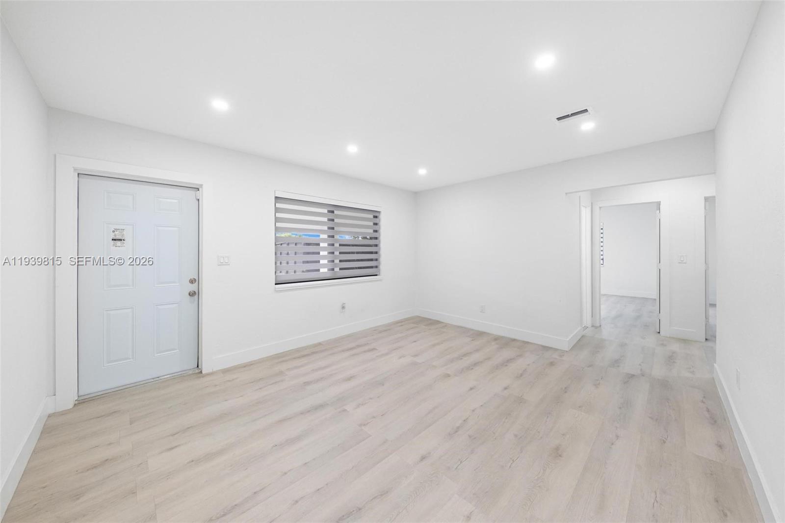 2250 Northwest 95th Street Miami, FL 33147 - Photo 5 of 26 an empty room with wooden floor and windows