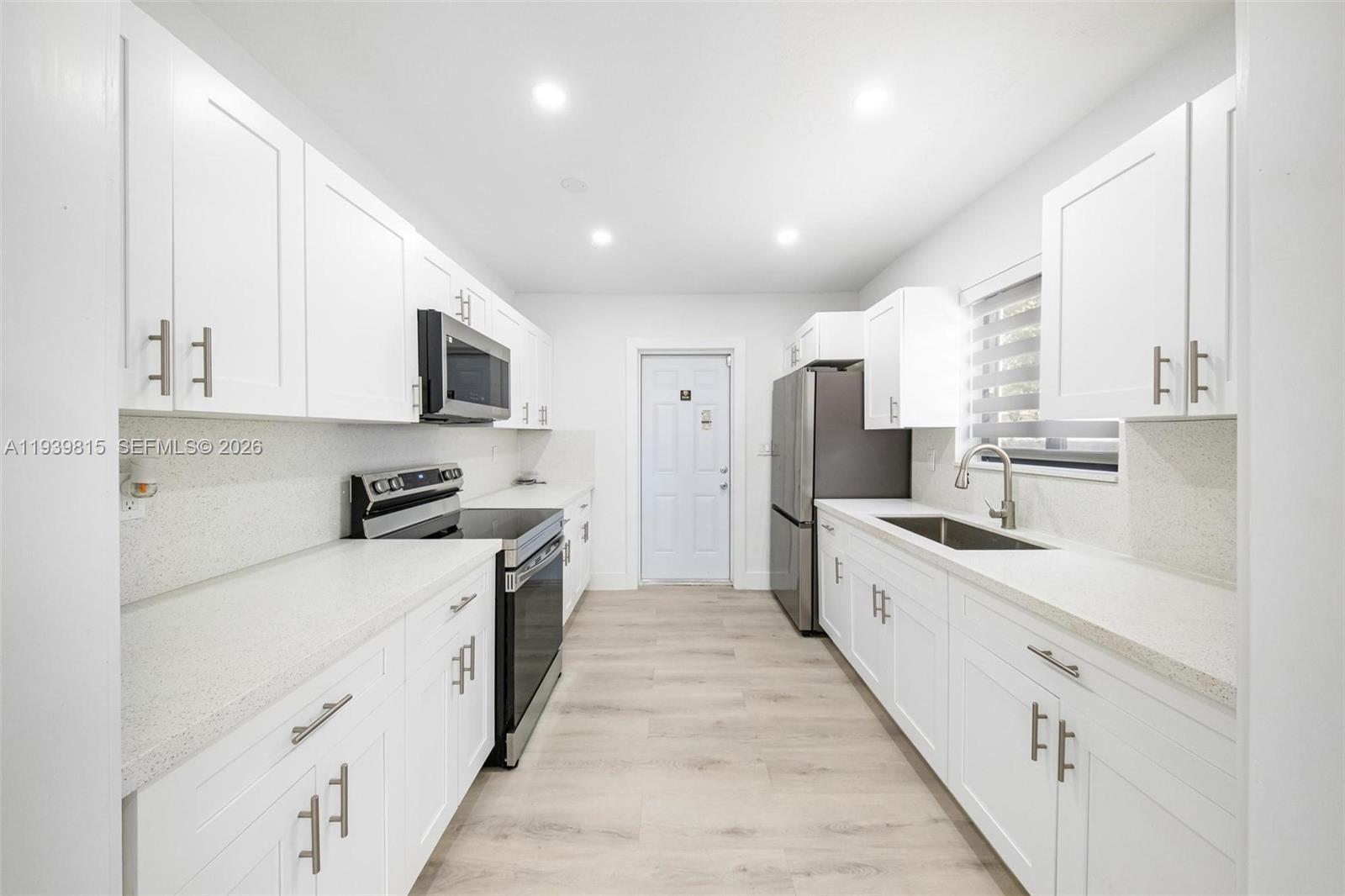 2250 Northwest 95th Street Miami, FL 33147 - Photo 10 of 26 a large kitchen with stainless steel appliances lots of white cabinets