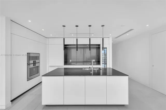 a kitchen with kitchen island a counter top space cabinets and stainless steel appliances