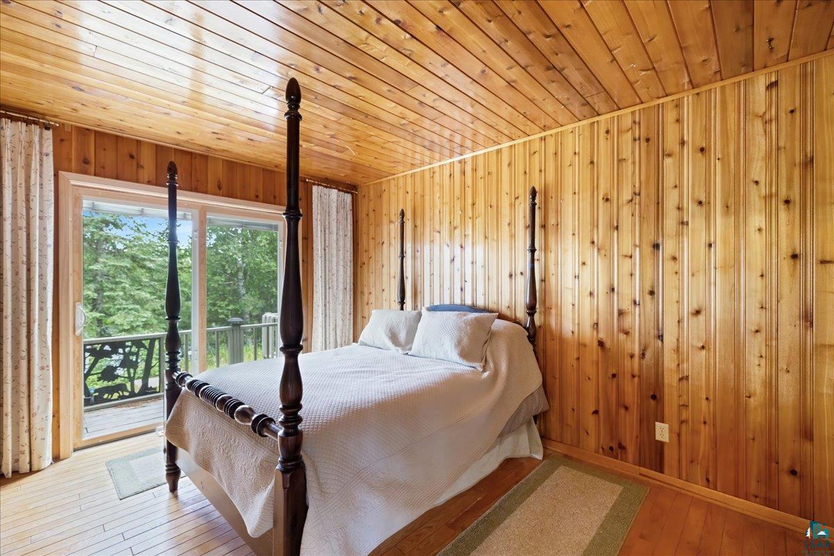 1804 North Bay Road Ely, MN 55731 - Photo 18 of 37 Bedroom with wood ceiling, access to exterior, wooden walls, and light hardwood / wood-style flooring