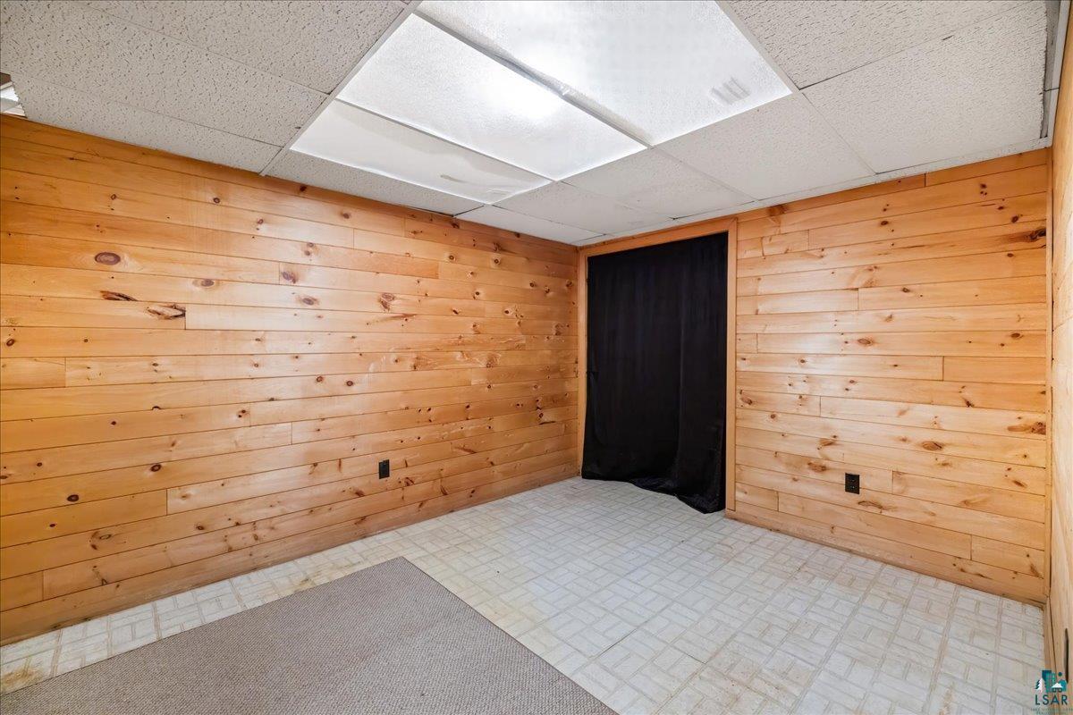 1804 North Bay Road Ely, MN 55731 - Photo 26 of 37 Tiled empty room with a drop ceiling and wooden walls
