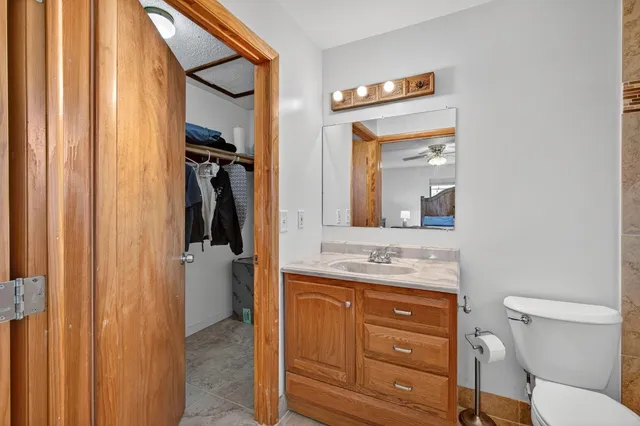 a bathroom with a granite countertop sink mirror vanity and toilet