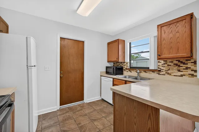 a kitchen with stainless steel appliances granite countertop a refrigerator and a sink